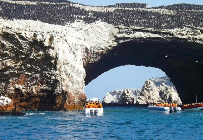 Лодки при скалната арка на островите Балестас край Паракас, Перу.